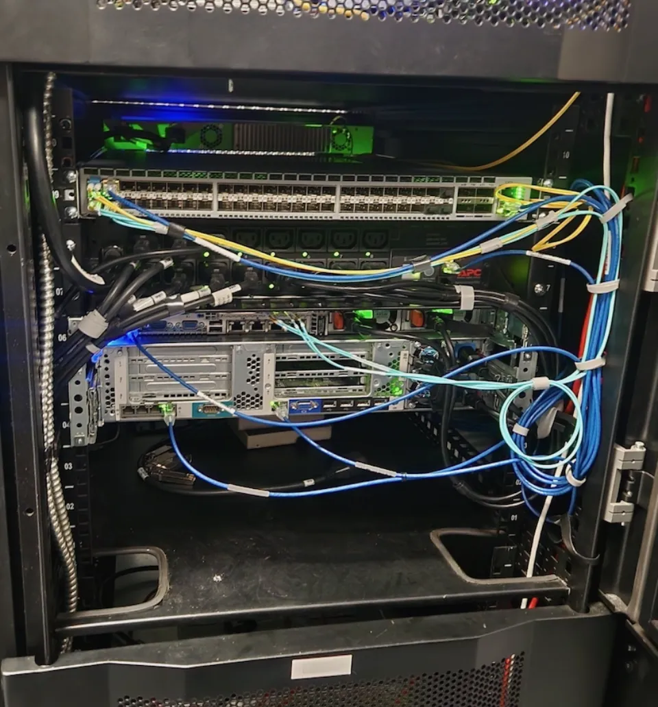 Rear rack view of the colocation setup after updates a few months after initial setup showcasing better cable management and hardware layout.